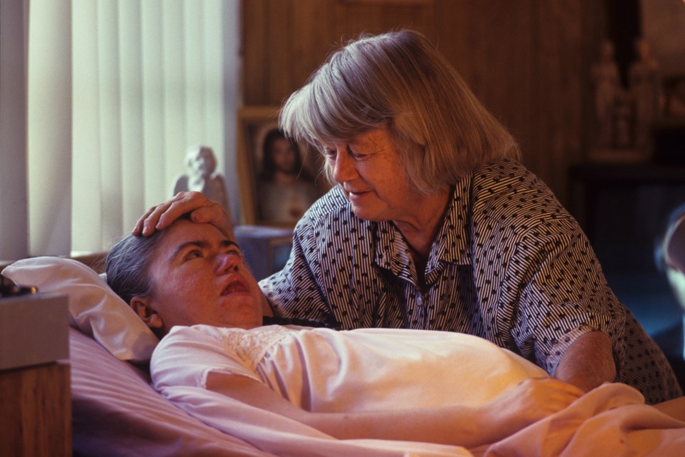 A woman tending to her daughter who is in a diabetic coma.