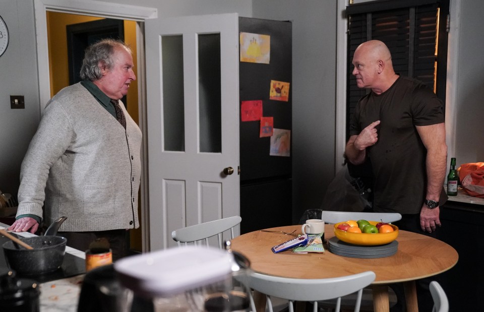 Two men arguing in a kitchen.