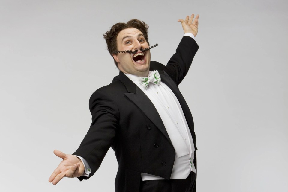 Gio Compario, opera singer, in a tuxedo, singing.