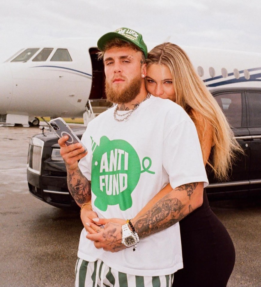 Jake Paul and his girlfriend pose in front of a private jet and luxury car.