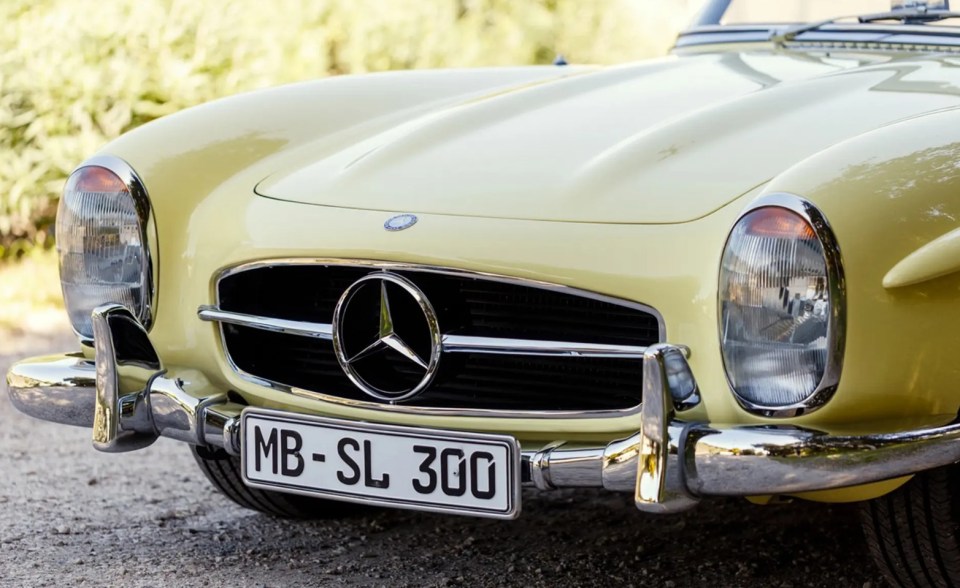 Close-up of a yellow Mercedes-Benz 300 SL Roadster.