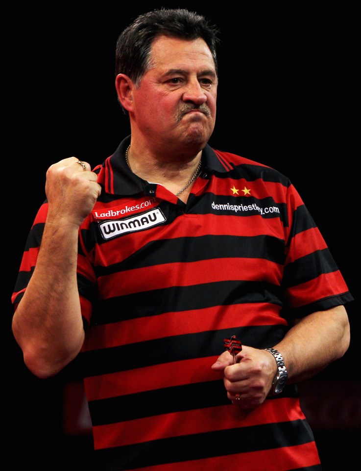 Dennis Priestley of England reacts to a throw during a darts match.