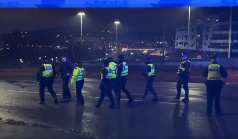 Police officers at night near an apartment building.