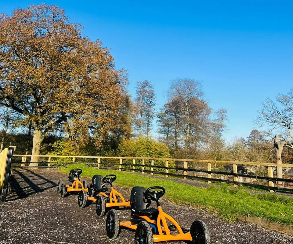 Three orange go-karts parked in a row at Bucklebury Farm.