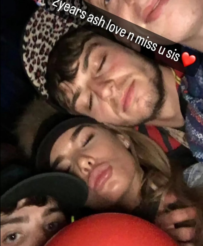 Instagram post of four people cuddling, with text overlay reading "2 years ash love n miss u sis".