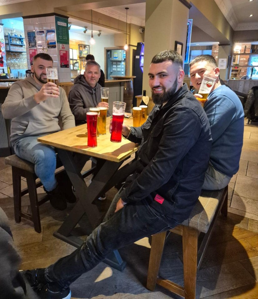 Four men sitting at a pub table, enjoying pints of beer.