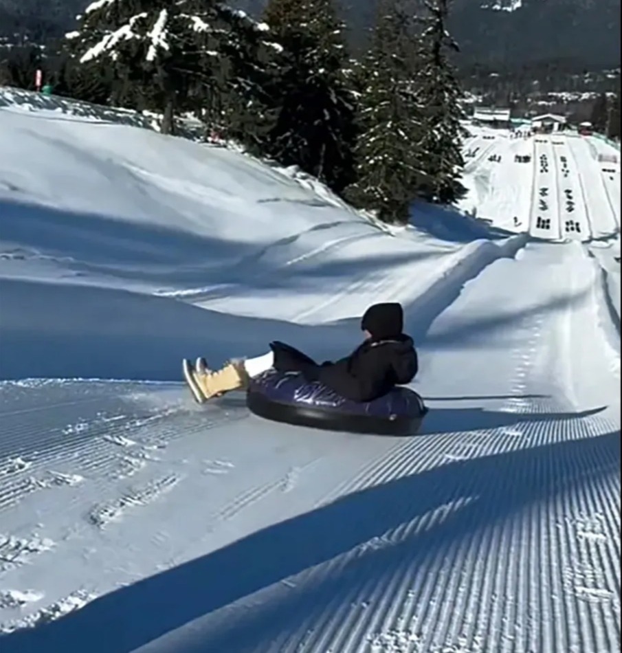 Person snow tubing down a hill.