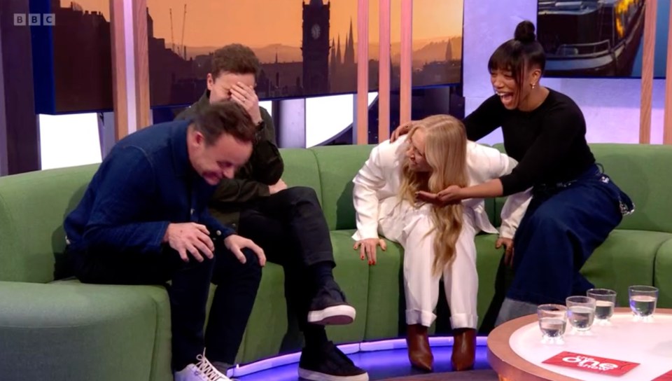 Screenshot of four people laughing on a talk show.