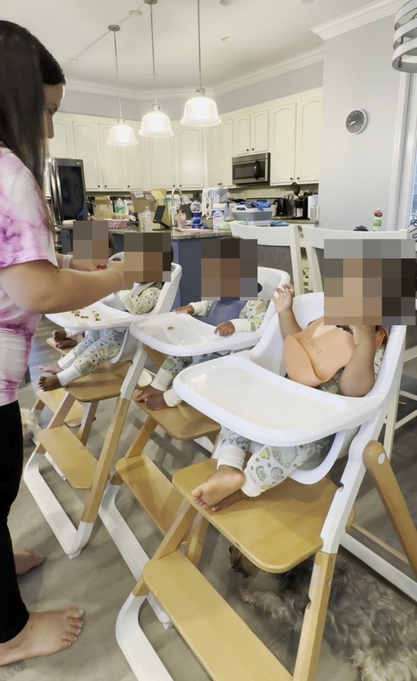 A woman feeding quadruplets in high chairs.