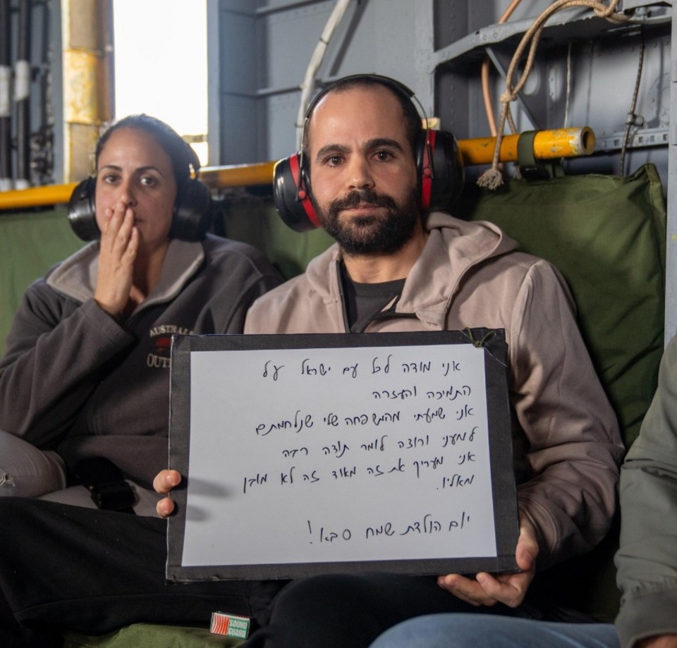 Released hostage holding a sign thanking the people of Israel.