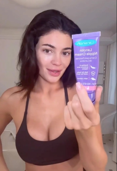 Woman holding lanolin nipple cream.