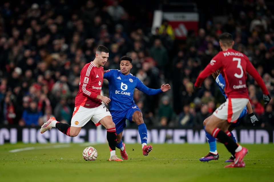 Manchester United's Diogo Dalot, left, and Leicester's James Justin challenge for the ball during the English FA Cup fourth round soccer match between Manchester United and Leicester City at the Old Trafford stadium in Manchester, England, Friday, Feb. 7, 2024. (AP Photo/Dave Thompson)