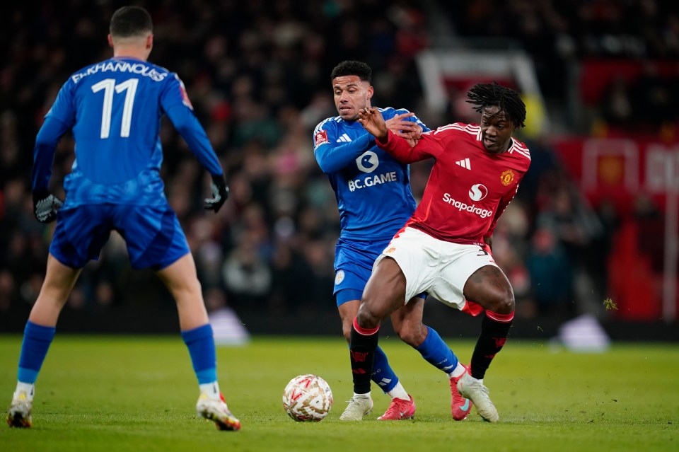 Manchester United's Kobbie Mainoo, right, and Leicester's James Justin, centre, challenge for the ball during the English FA Cup fourth round soccer match between Manchester United and Leicester City at the Old Trafford stadium in Manchester, England, Friday, Feb. 7, 2024. (AP Photo/Dave Thompson)