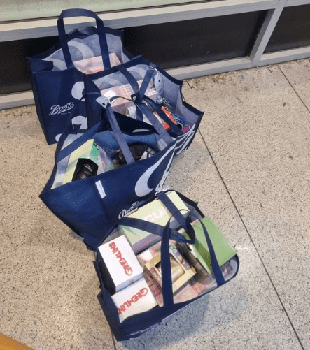 Three full Boots shopping bags on the ground.