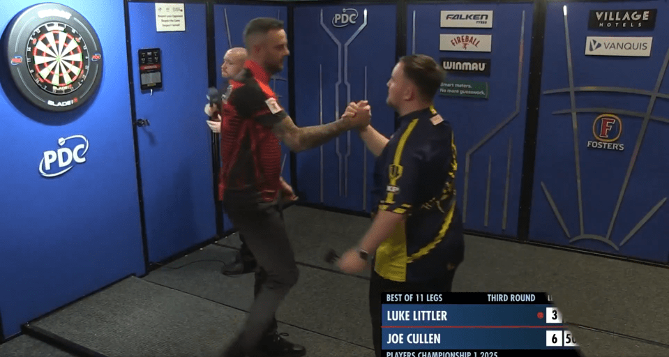 Two darts players shaking hands after a match.