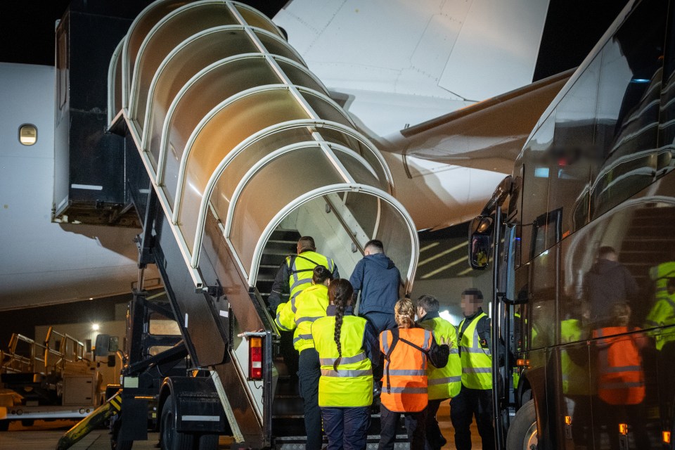 People disembarking a plane and boarding a bus.