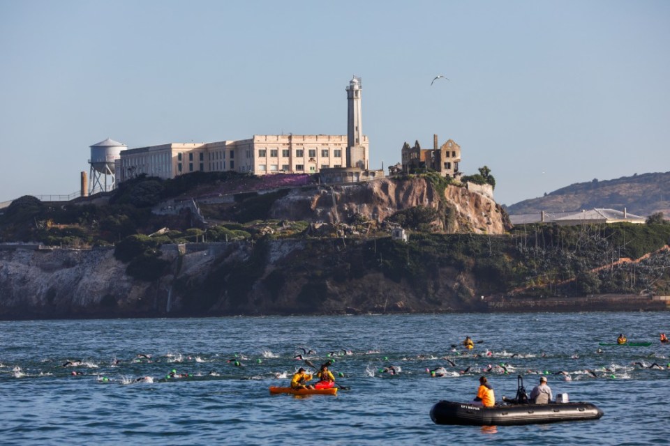 Competitors swim past Alcatraz during the 39th annual Escape from Alcatraz Triathalon in San Francisco, California, on Sunday, June 9, 2019. Over 2,000 athletes swam the 1.5 miles to shore followed by an 18-mile bike ride and an 8-mile run through San Francisco. The race is considered one of the oldest and most difficult triathlons with many elite participants. (Photo by Gabrielle Lurie/San Francisco Chronicle via Getty Images)