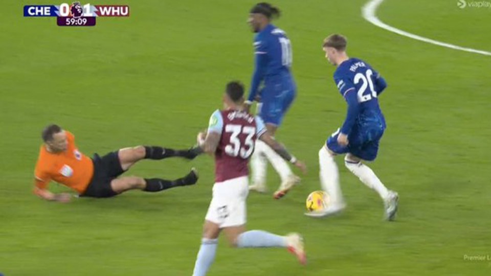 Soccer referee falling during a game.