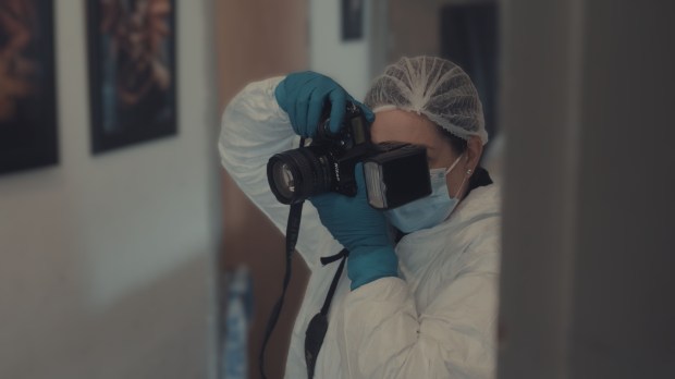 Crime scene investigator photographing evidence.