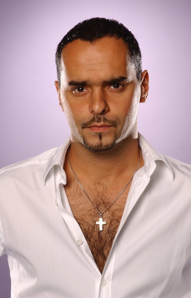 Headshot of Michael Greco wearing a white shirt and cross necklace.