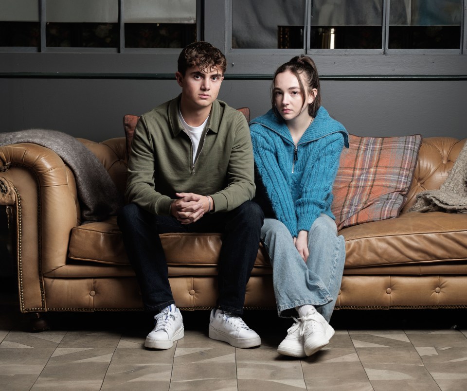 Teenage boy and girl sitting on a couch.