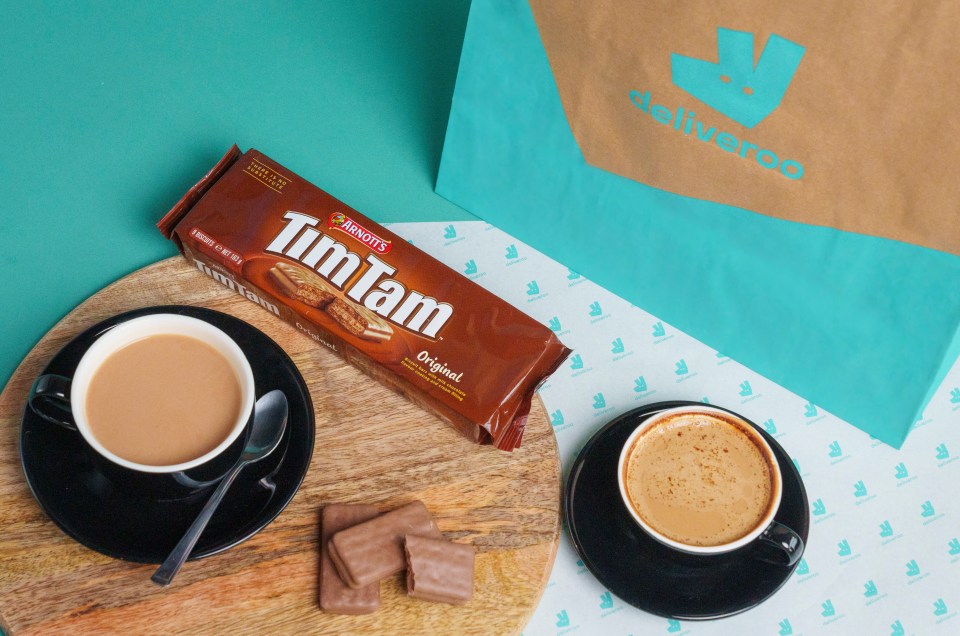 Tim Tam biscuits, two cups of coffee, and a Deliveroo bag.