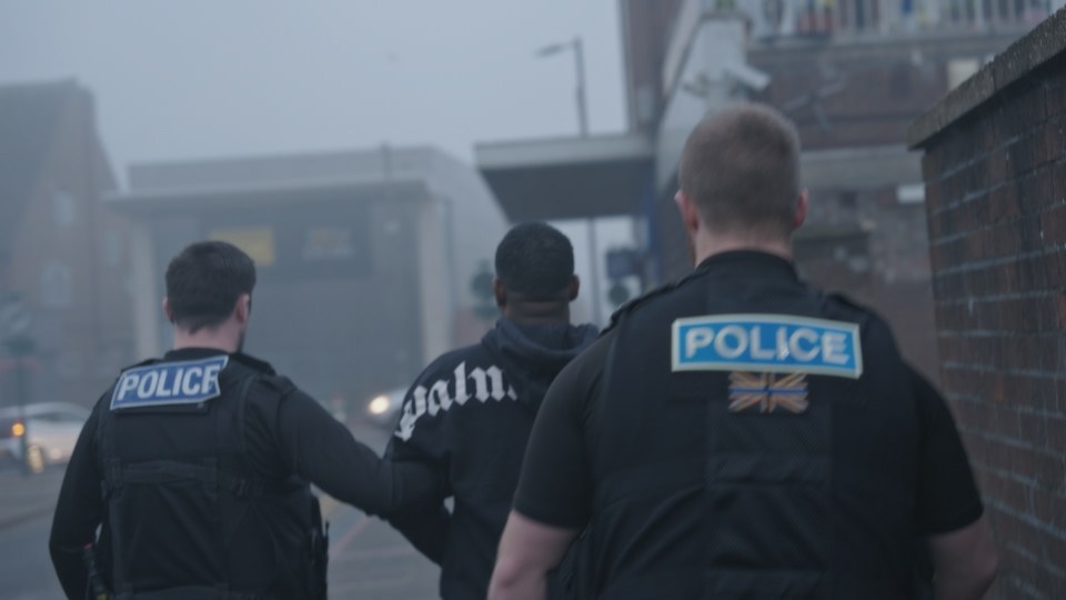 Police officers escorting a suspect.