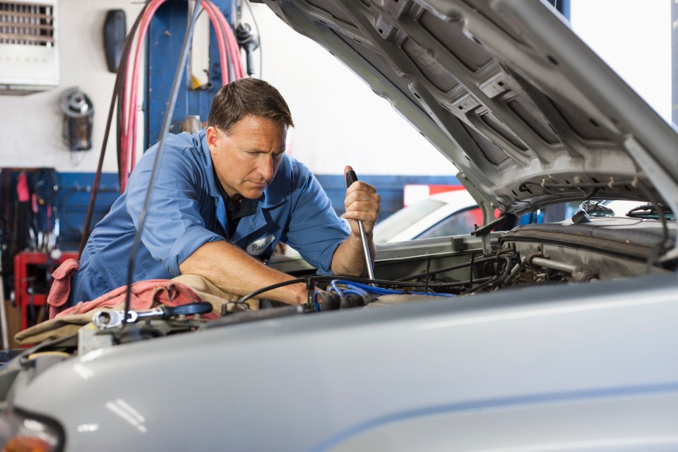 A mechanic repairing a car engine.