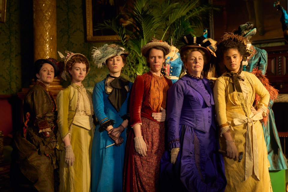 Seven women in late 19th-century dresses.