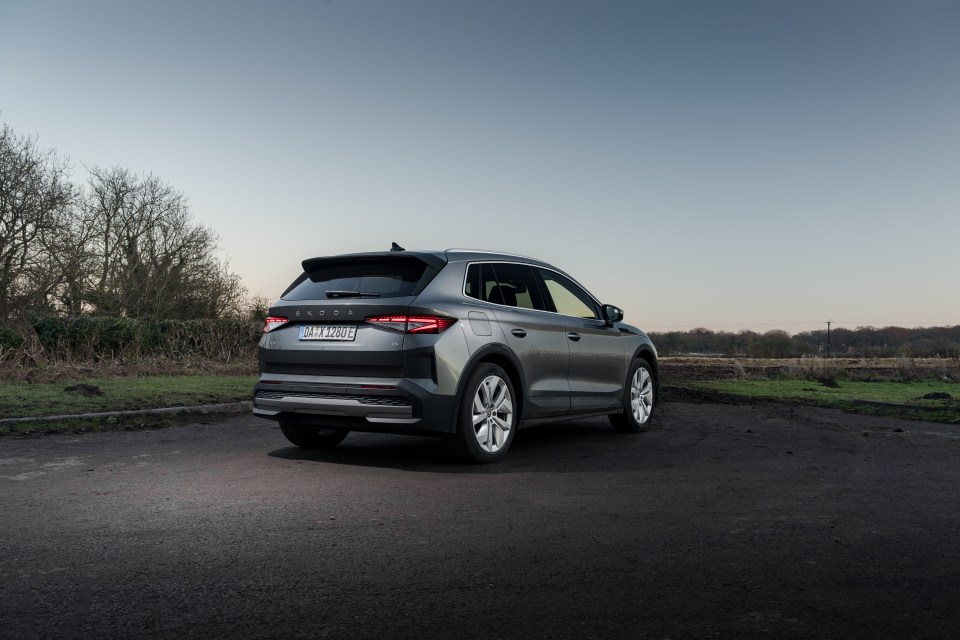 Rear view of a silver Skoda Enyaq iV parked in a lot.