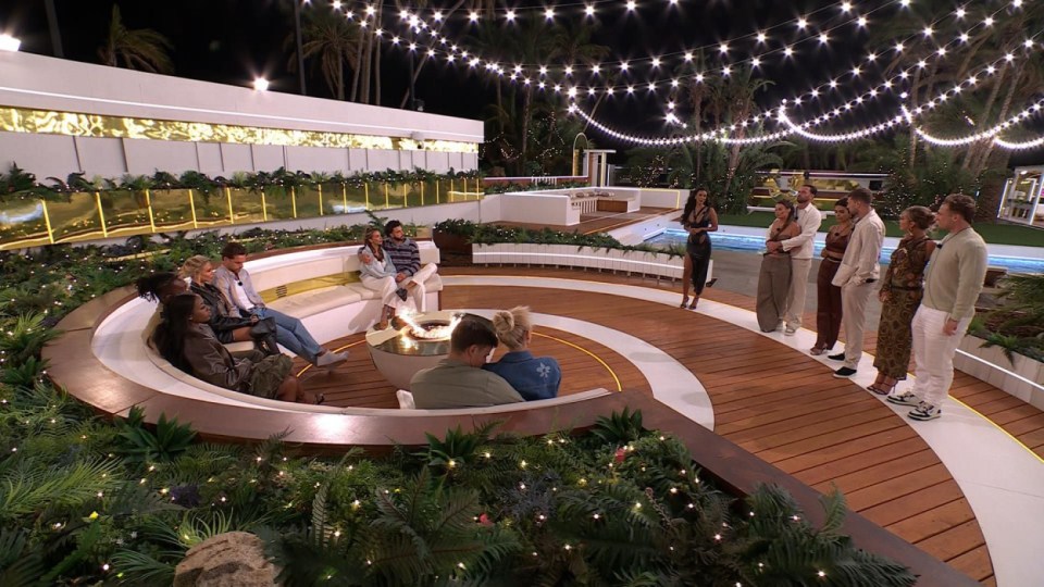 "Love Island: All Stars" contestants gathered around a fire pit.