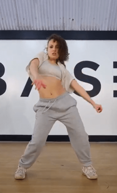 Woman dancing in grey sweatpants.