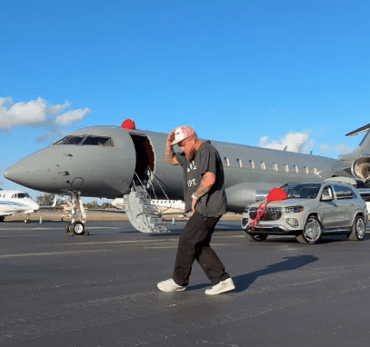 Man walking on tarmac near a private jet and SUV.