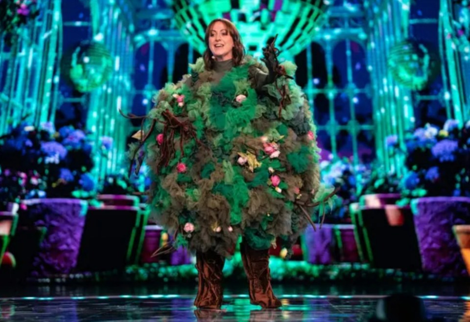 Woman in a tree costume on stage.