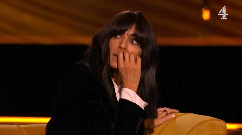 Screenshot of a woman sitting on a couch, appearing nervous.