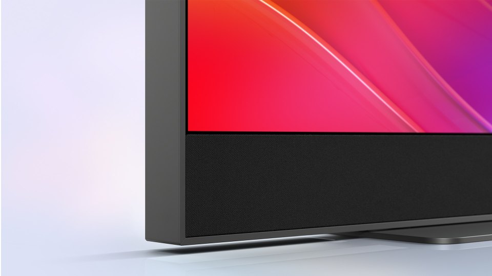 Close-up of a television's bottom edge, showcasing its speaker.