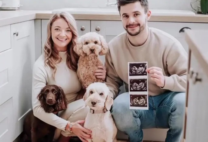 Couple with two dogs announcing pregnancy with ultrasound image.