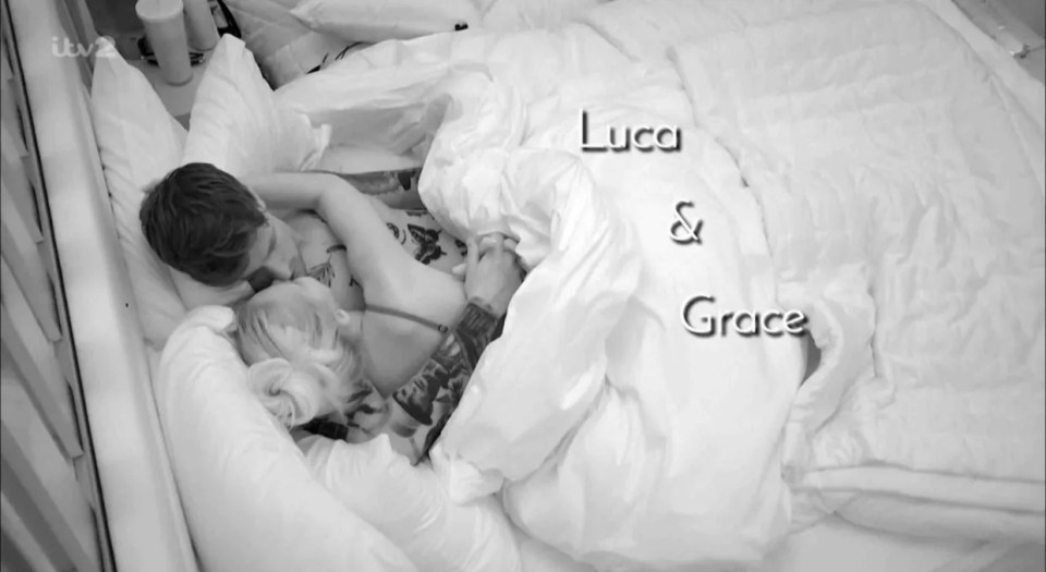 Luca and Grace cuddling under a blanket in bed.