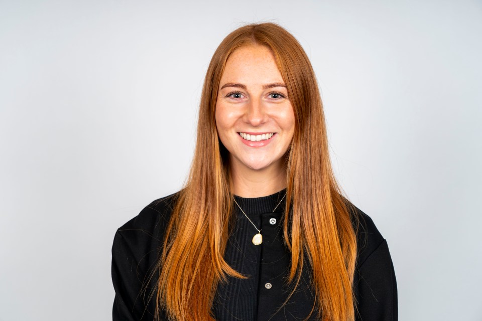 Portrait of a smiling woman with long red hair.