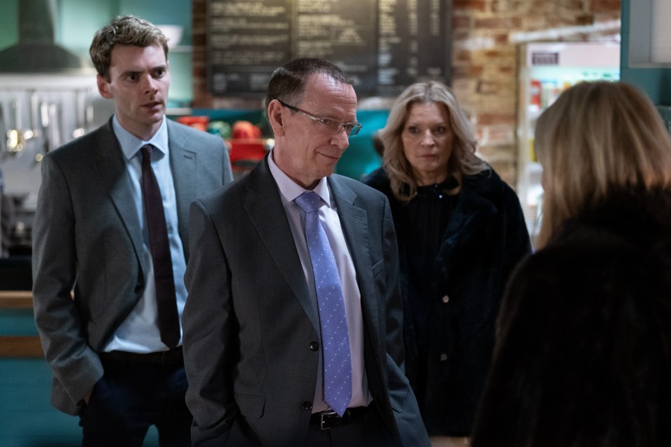 Scene from EastEnders showing four actors in suits.