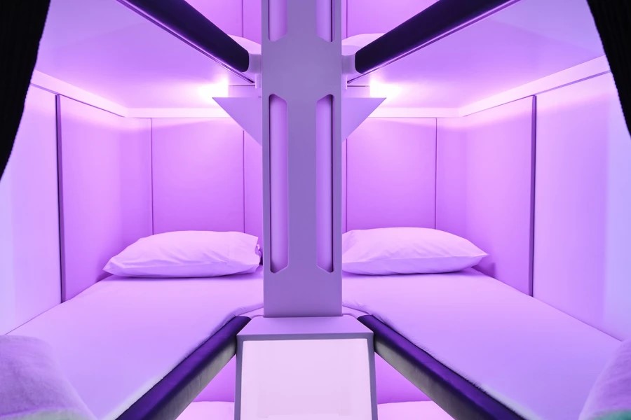 Airline bunk beds with purple lighting.