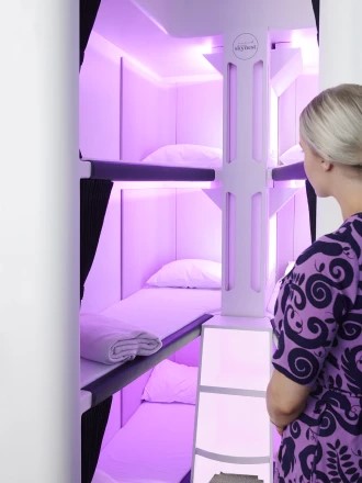 Airline bunk beds with purple lighting.