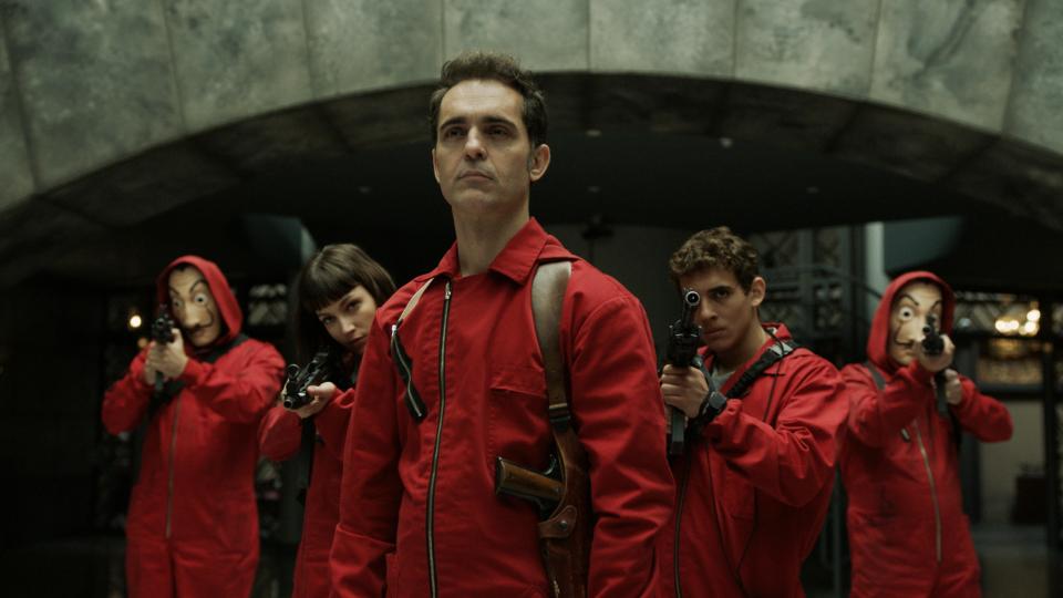 Money Heist cast members aiming guns.