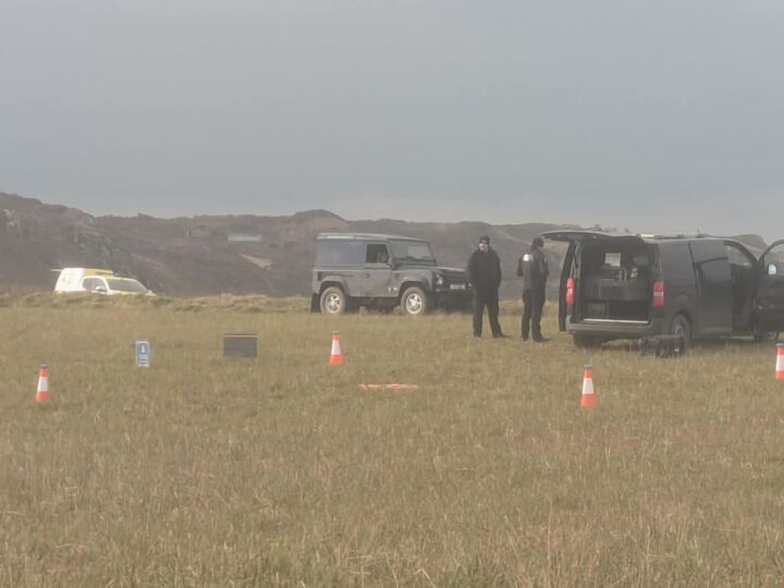 Emergency vehicles and personnel at a coastal scene.