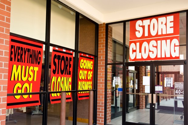 Store closing signs in a storefront window.