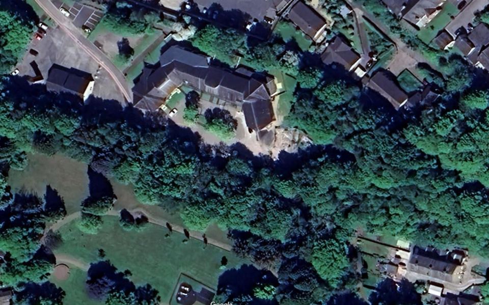 Aerial view of a building site with surrounding trees.