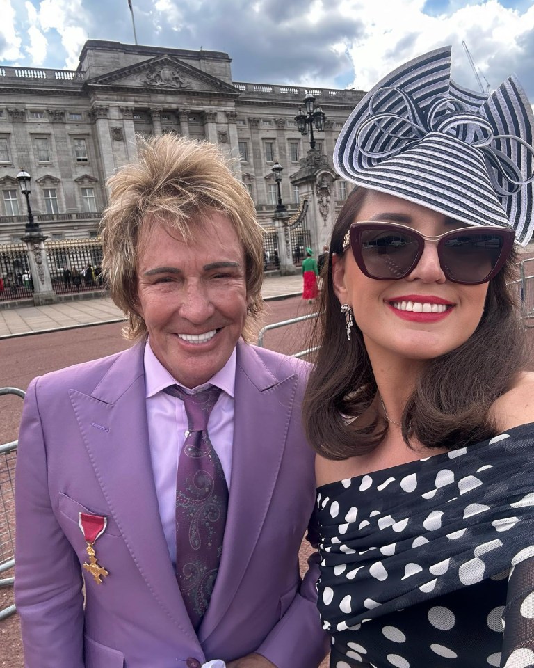 Photo of two people in front of Buckingham Palace.