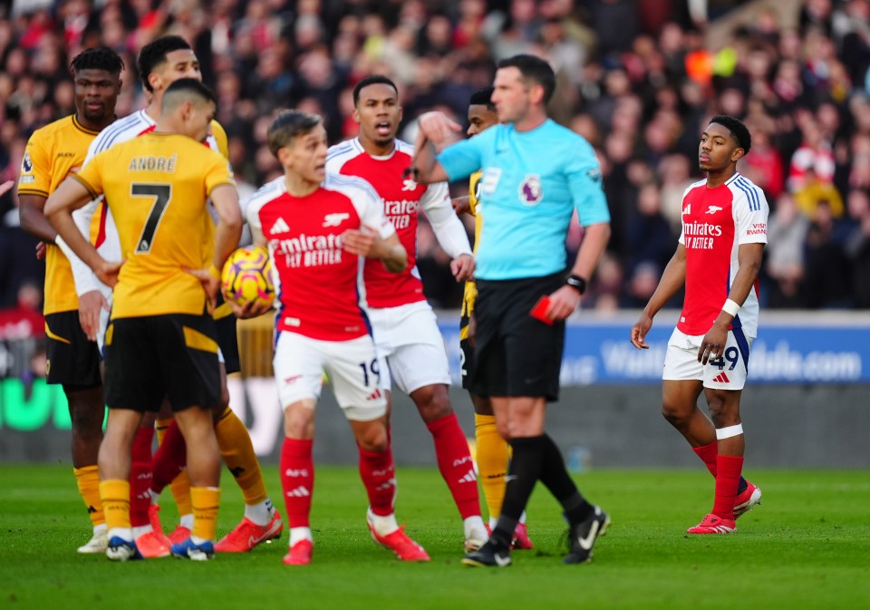 Arsenal player Myles Lewis-Skelly receives a red card from the referee.