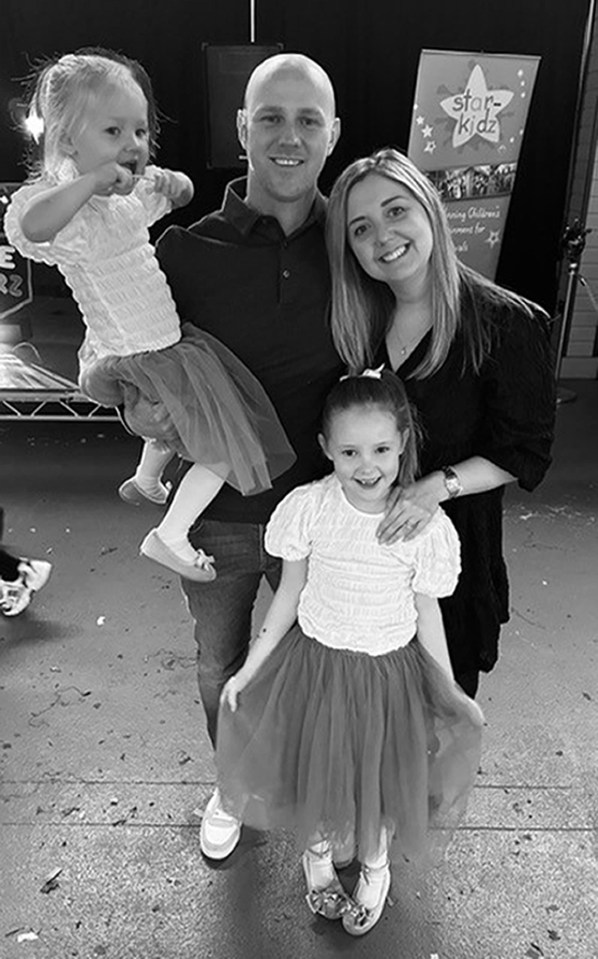 Black and white photo of a family with two young daughters.