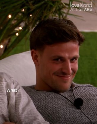 Screenshot of a man reacting to two bombshells surprising the Love Island villa.